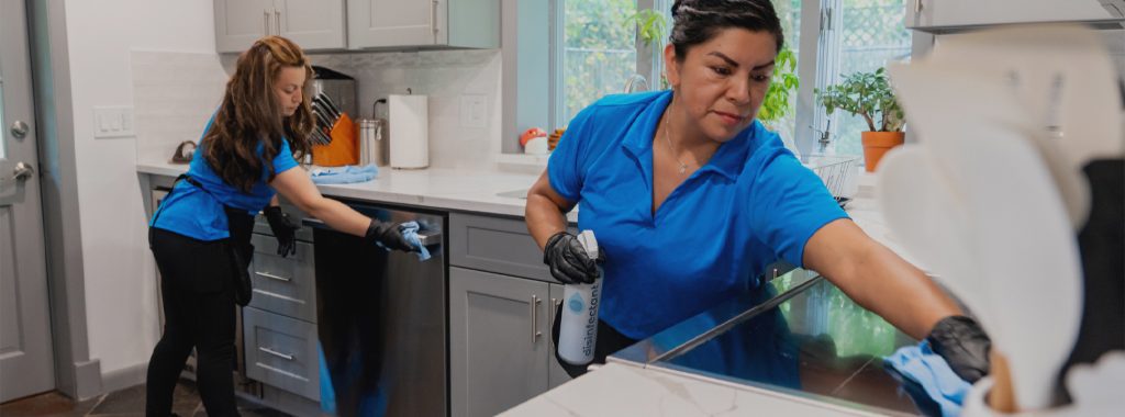 Professional housecleaner completing tasks included in a regular cleaning service.