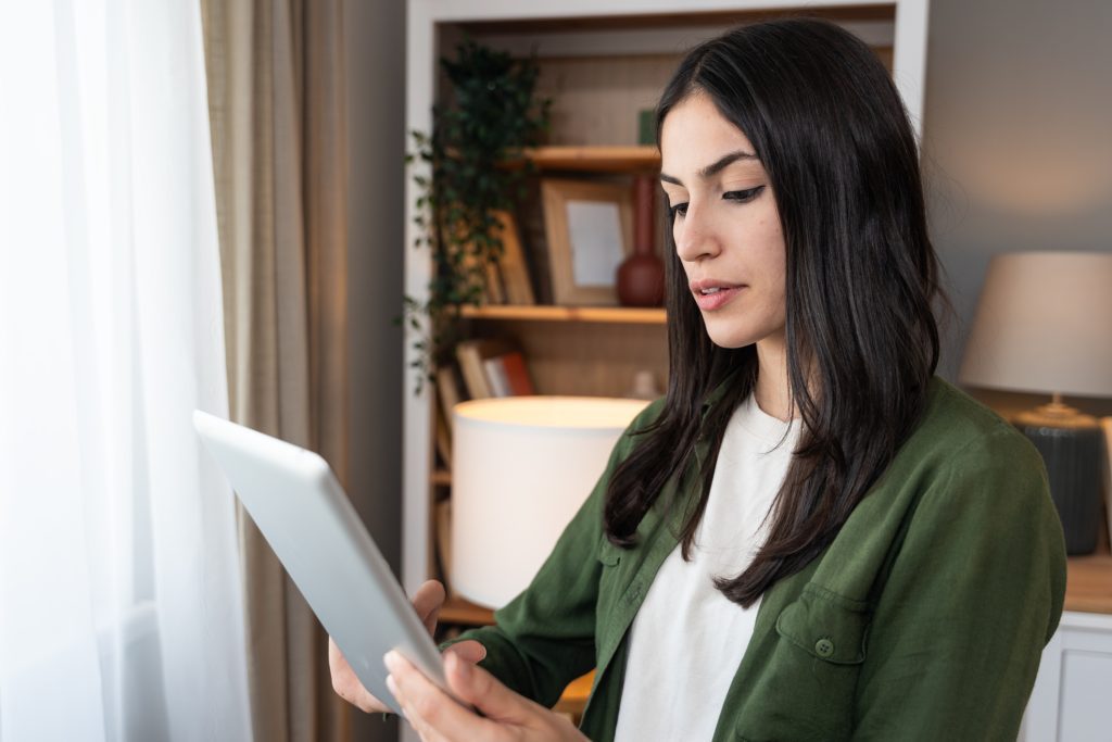 Homeowner reviewing cleaning service details on a tablet before booking.