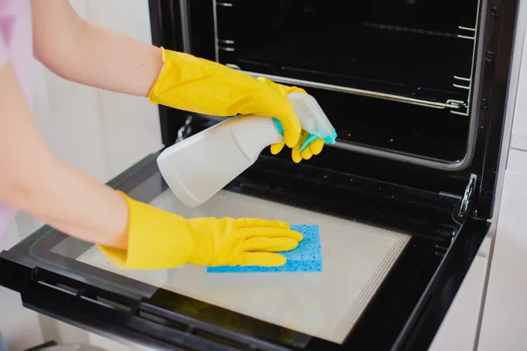 Image of a cleaner cleaning a dirty oven