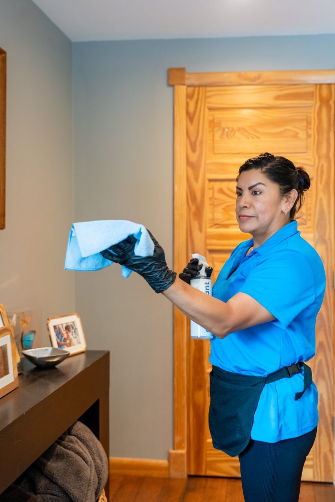 How safe are your cleaning products? Cleaner spraying a microfiber cloth before wiping a surface