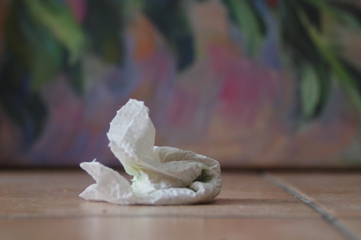 Crumpled white paper towel on a tile floor, representing the white paper towel test used to check floor cleanliness