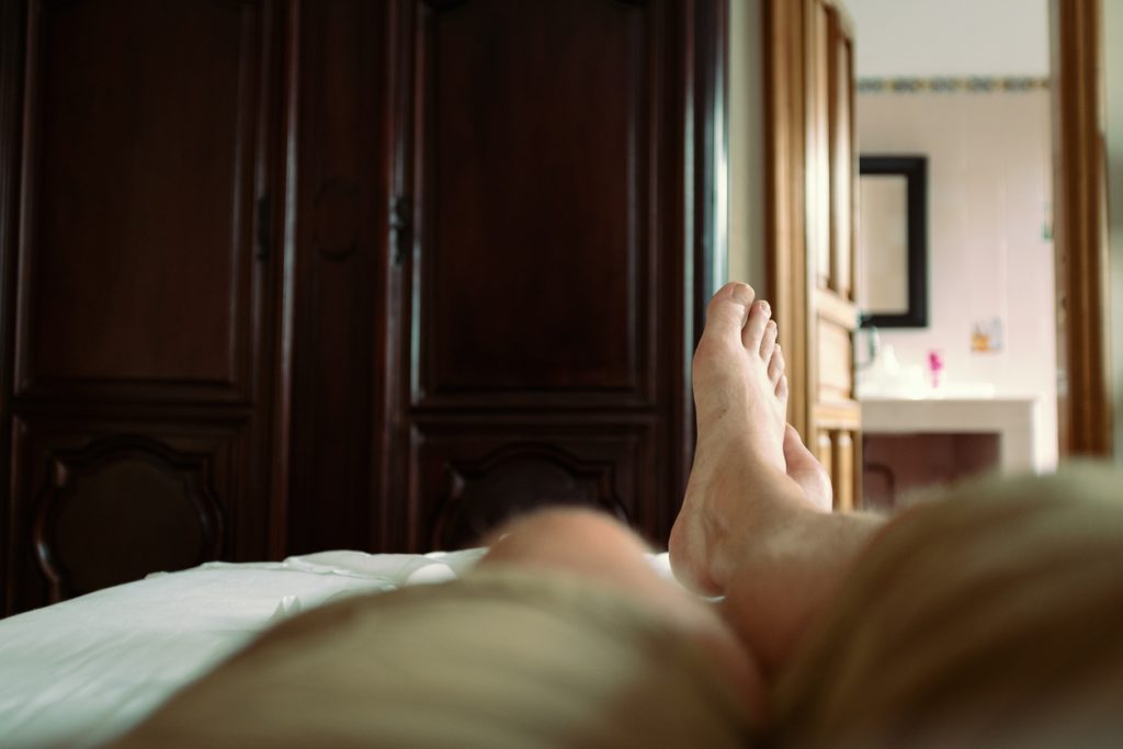 Person lying on a bed after housecleaning, viewed from a first-person perspective