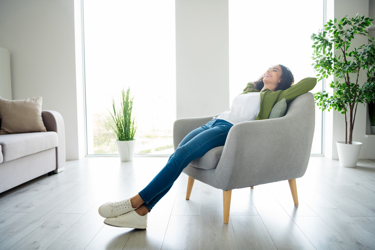 Relaxed person in a clean living room illustrating does a clean home affect mental health.