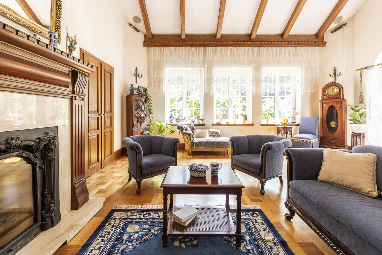 Elegant living room in an older home with original wood beams, hardwood floors, and detailed trim
